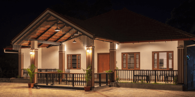 A small house illuminated at night, nestled among lush coffee estates in the serene Mudigere region.