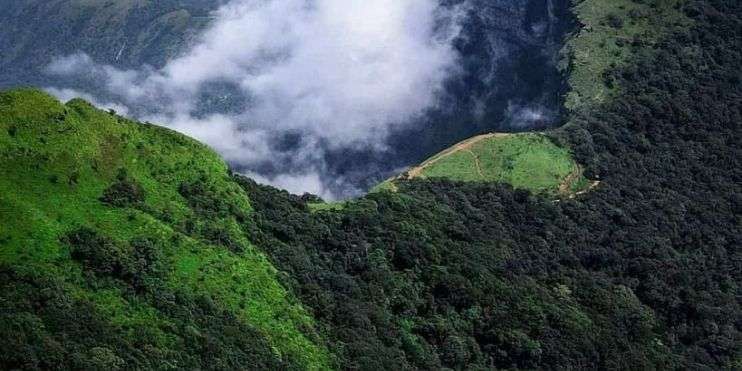 Aerial view of mountains and clouds, evoking the legend of Rani Padmini Devi at the Rani Jhari viewpoint.