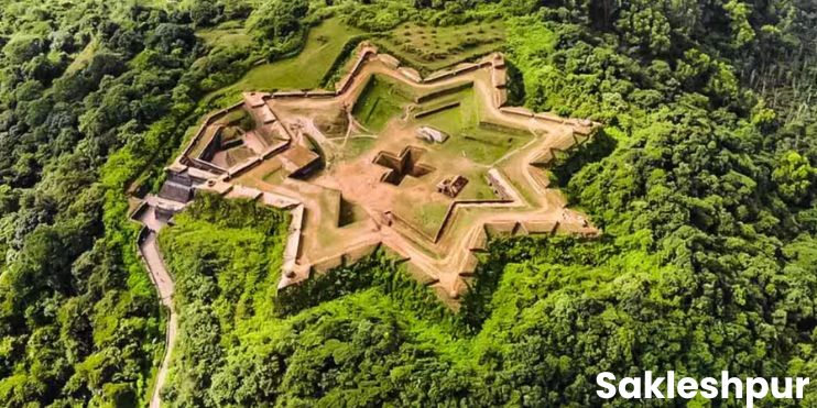 Aerial view of a castle surrounded by lush green forest, showcasing the beauty of Sakleshpur's landscape.