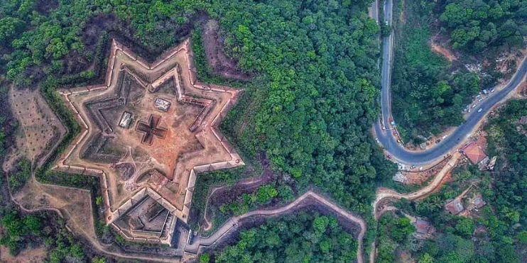 Aerial view of a star-shaped structure surrounded by dense forest in Sakleshpur, a serene hill station in the Western Ghats.